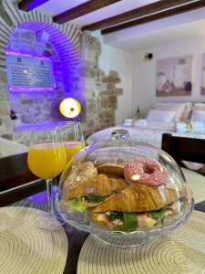 un tazón de vidrio de comida y un vaso de zumo de naranja en Diocletian Wine studio apartment en Split