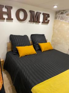 a bedroom with a bed with two yellow pillows at LOFT AUTHENTIQUE 3 STARS Terrasse VIEUX PORT in La Ciotat