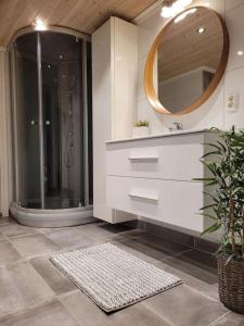 a bathroom with a sink and a shower with a mirror at Riverside apartment in Skien in Skien