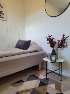 a bedroom with a bed and a table with a mirror at Riverside apartment in Skien in Skien