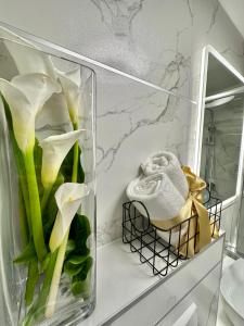 un jarrón de cristal con flores en un estante del baño en Diocletian Wine studio apartment en Split