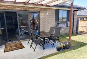 a patio with a table and chairs on it at Queen Bed Guest Room in Brand New House in Leppington