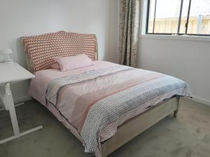 a bedroom with a bed and a table and a window at Queen Bed Guest Room in Brand New House in Leppington