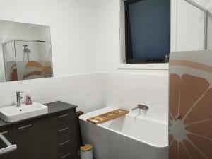 a bathroom with a sink and a bath tub at Queen Bed Guest Room in Brand New House in Leppington