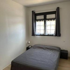 a bedroom with a bed and a window at Au vert, proche des plages in Les Anses-dʼArlets