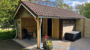 Una gran caseta de madera para perros con una silla dentro en Villa Anna with sauna in Winterswijk, en Winterswijk