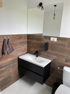 a bathroom with a sink and a mirror and a toilet at Lawendowy Ogród in Jeżewo
