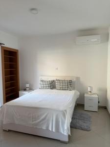 - une chambre blanche avec un lit et 2 tables de chevet dans l'établissement Holiday Apartments TF, à Praia