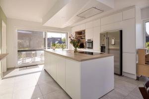 a large kitchen with white cabinets and a counter top at Lichtrijke woning vlakbij Leuven in Herent +8 photos