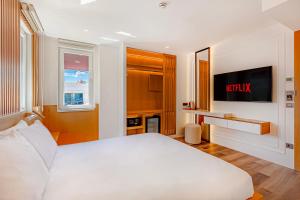 a bedroom with a white bed and a tv at Dulcet Hotel in Antalya