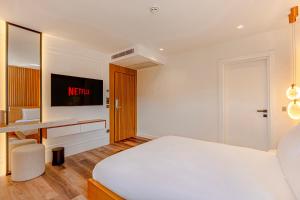 a white bedroom with a bed and a desk at Dulcet Hotel in Antalya