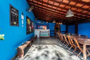 um restaurante com paredes azuis e mesas e cadeiras de madeira em Positano Ilhabela Lodges em Ilhabela