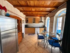 uma cozinha com uma mesa e cadeiras e um frigorífico em Oasis Camp Portugal em Lagoa