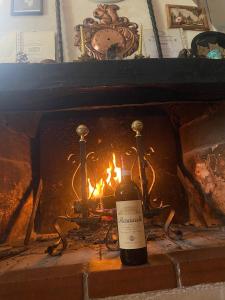 a bottle of wine sitting in front of a fireplace at Da Nonna Gina in Pescasseroli