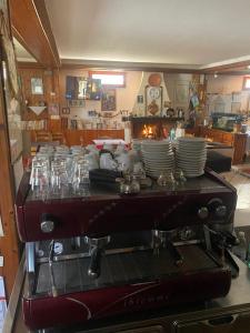 una cafetera con platos y vasos encima en Da Nonna Gina, en Pescasseroli