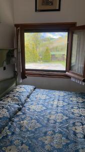 una camera da letto con finestra e un letto con copriletto blu di Da Nonna Gina a Pescasseroli