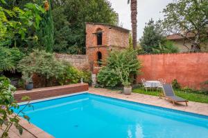 una piscina en un patio trasero con un edificio de ladrillo en Chambre de charme dans une propriété du 18ème, en Roquettes