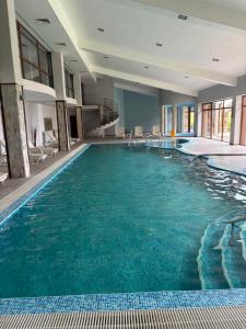 a large swimming pool with blue water in a building at Panorama Resort Bansko Wellness & Recreation in Bansko