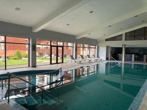 a swimming pool with chairs and tables in a building at Panorama Resort Bansko Wellness & Recreation in Bansko