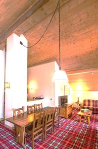 a living room with a wooden table and chairs at Arc 1950, Hameau du Glacier, Dernier étage , 63m2 , 5m de hauteur sous plafond dans le séjour, Cheminée, Balcon Sud, Piscine, ski aux pieds in Bourg-Saint-Maurice