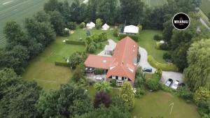 een luchtzicht op een groot huis met een rood dak bij B&B in woonboerderij vlakbij Lemmer in Rutten