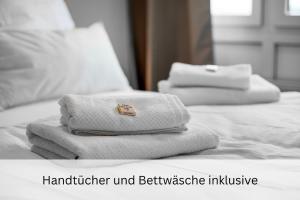 dos toallas blancas sentadas encima de una cama en Business Frankfurt Family FreeParking Netflix Wifi, en Dreieich
