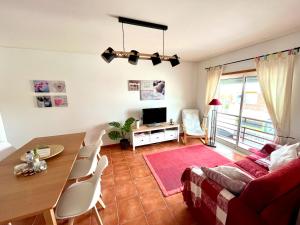 ein Wohnzimmer mit einem Tisch und einem Sofa in der Unterkunft HSH Gomeira Cabanas Beach in Cabanas de Tavira