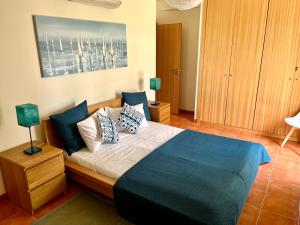 um quarto com uma cama grande com almofadas em HSH Gomeira Cabanas Beach em Cabanas de Tavira