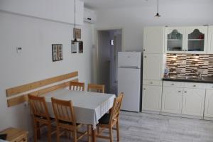 eine Küche mit einem Tisch und Stühlen sowie einem Kühlschrank in der Unterkunft Zamárdi Trafóház in Zamárdi