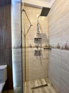 y baño con ducha y puerta de cristal. en ApartHotel Near the Sea, en Mamaia Nord – Năvodari