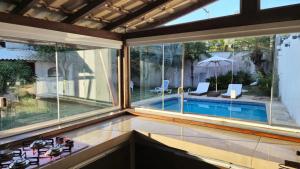 a house with a view of a swimming pool through windows at Aldeia Maravista in Niterói