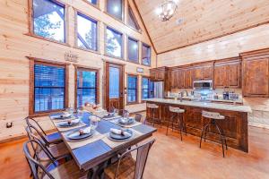 a dining room with a table and chairs in a kitchen at The Luxurious Blue Sky Lodge is EPIC! in Broken Bow