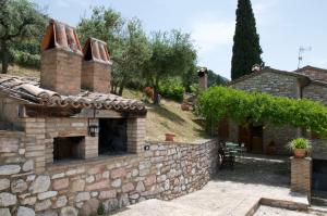 an external view of a stone house with a brick wall at Casa Vacanze L'olivo al Borghettaccio in Assisi
