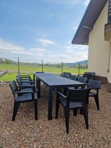 a black picnic table and chairs in front of a building at Dom w górach in Lipnik