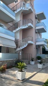 a building with balconies and potted plants in front of it at Vila Melina in Himare
