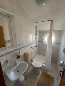 a bathroom with a sink and a toilet and a mirror at Apartmani Šaldi in Pakoštane