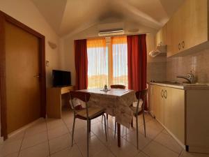 a kitchen with a table and chairs in a room at Apartmani Šaldi in Pakoštane