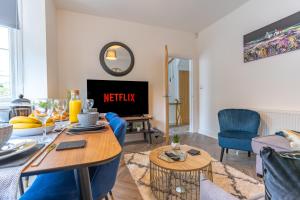 sala de estar con mesa y TV en New 4BR family home sleeps 8 -10 people with free parking and contractors welcome, en Birmingham