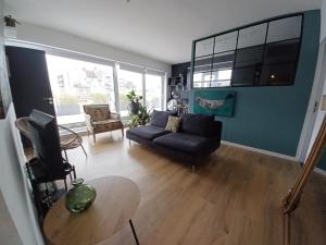 a living room with a couch and a table at Seaview Penthouse Oostende in Ostend