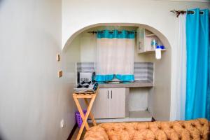 a small kitchen with a blue curtains and a table at ndush home in Rutara
