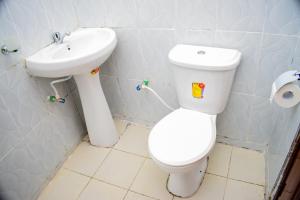 a bathroom with a toilet and a sink at ndush home in Rutara