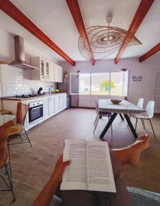 osoba czyta książkę w kuchni w obiekcie Apartamento Casa Rosabella w mieście Caleta de Sebo