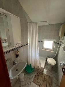 a white bathroom with a sink and a toilet at Apartmani Šaldi in Pakoštane
