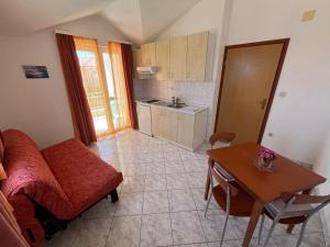 a living room with a red couch and a table at Apartmani Šaldi in Pakoštane
