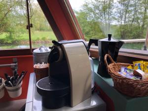 eine Kaffeemaschine auf einer Theke neben einem Fenster in der Unterkunft Péniche hollandaise cosy in Dole
