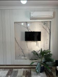 a wall with a flat screen tv on a wall at Quite apartment with positive vibes in New cairo