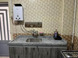 a sink in a kitchen with a counter top at Quite apartment with positive vibes in New cairo