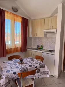 eine Küche mit einem Tisch, einem Tisch und Stühlen in der Unterkunft Apartmani Šaldi in Pakoštane