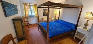 1 dormitorio con cama con dosel y sábanas azules en Casa Vacanze - 12 Maggio, en Campagnano di Roma