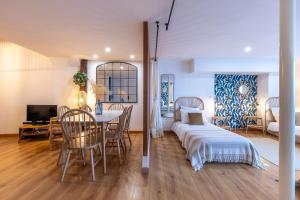 La Maison des Chalands في بلوا: غرفة معيشة مع سرير وغرفة طعام